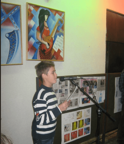 Martin reading his work at a microphone as a child